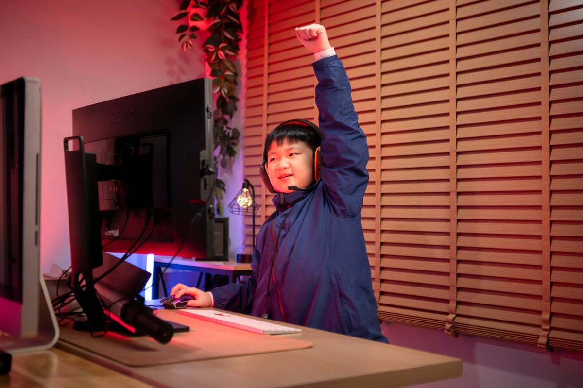 Gamer wearing headphones playing on a colorful gaming setup